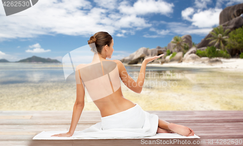 Image of beautiful woman in towel with bare top on beach