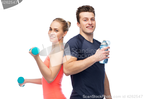 Image of sportive man and woman with dumbbell and water