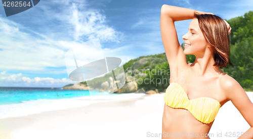 Image of happy woman in bikini swimsuit on tropical beach