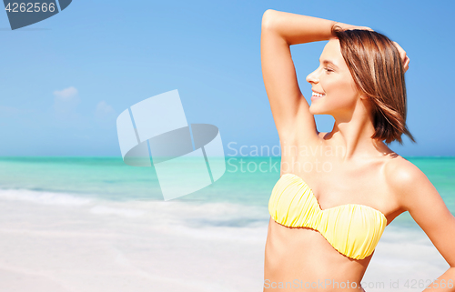 Image of happy woman in bikini posing on summer beach