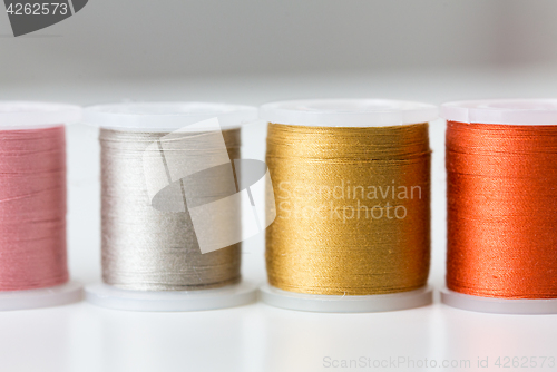 Image of row of colorful thread spools on table
