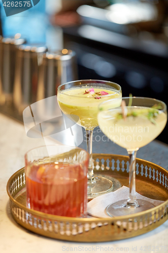 Image of tray with glasses of cocktails at bar