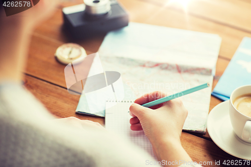 Image of close up of traveler hands with notepad and pencil