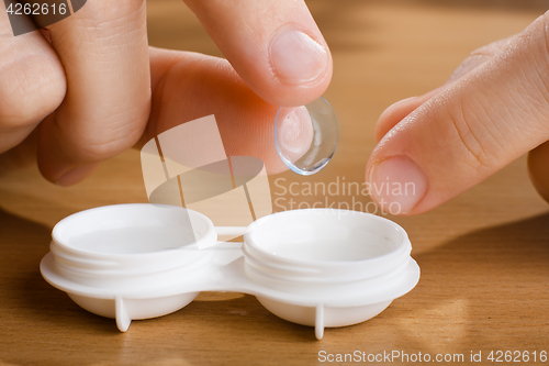 Image of hand with contact lens, closeup