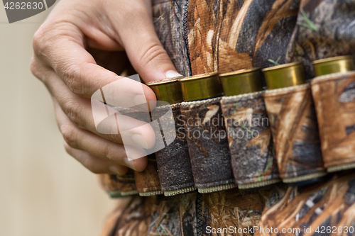 Image of hand pulling cartridge from the bandoleer