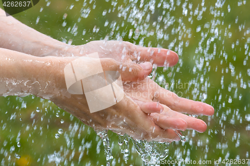 Image of hands under rain