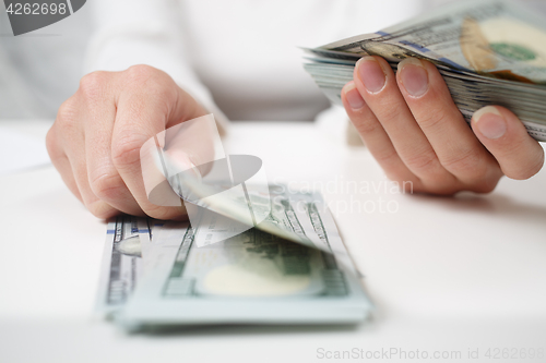 Image of Close up of woman with calculator counting money