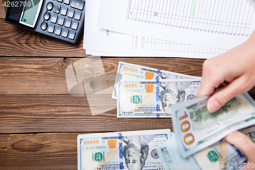 Image of Hands hold and counting us dollar banknotes