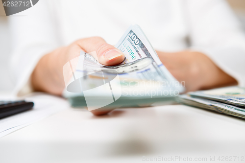 Image of Hands of person proposing money to you - closeup shot