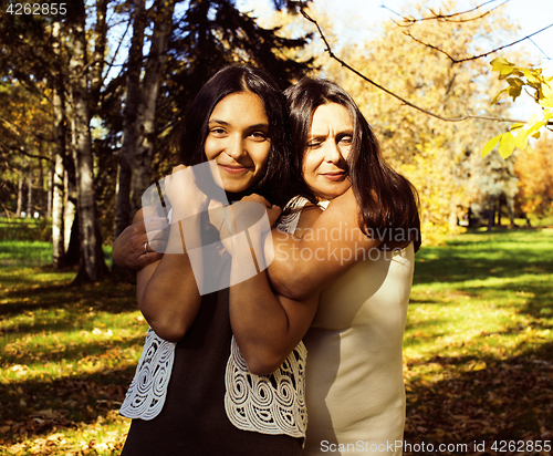 Image of mature real mother with daughter outside autumn fall in park