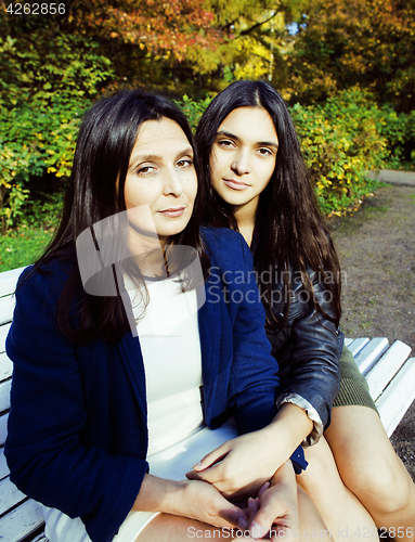 Image of mature real mother with daughter outside autumn fall in park