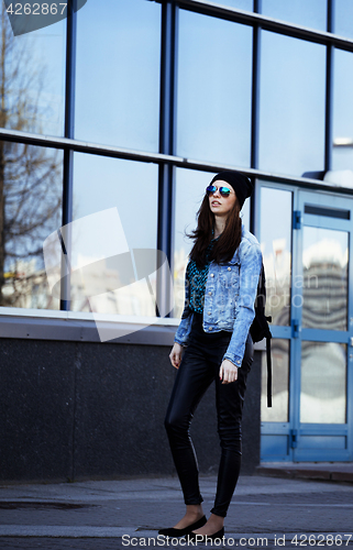 Image of young pretty girl near business building walking