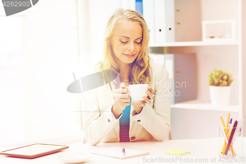 Image of happy businesswoman drinking coffee at office