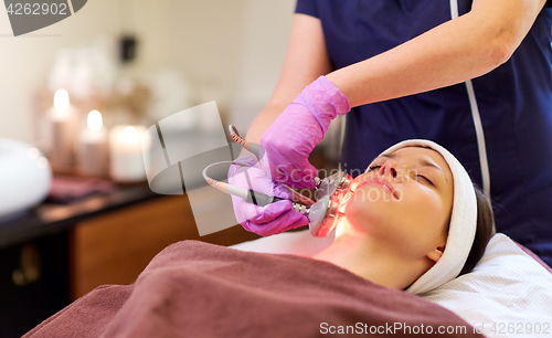 Image of young woman having face microdermabrasion at spa