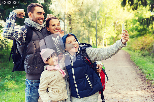 Image of family with backpacks taking selfie by smartphone