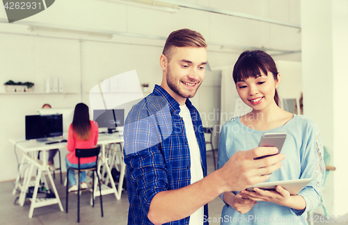 Image of couple with smartphone and tablet pc at office