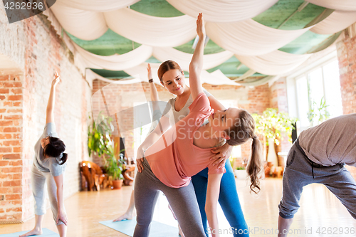 Image of group of people doing yoga exercises at studio