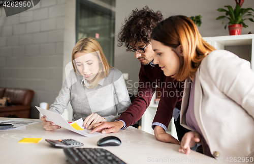Image of happy business team with papers in office