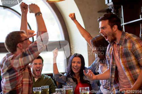 Image of football fans or friends with beer at sport bar