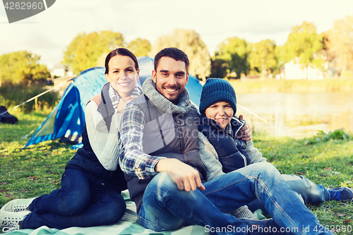 Image of happy family with tent at camp site