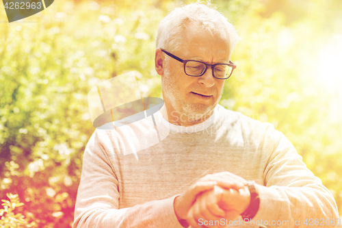 Image of senior man checking time on his wristwatch