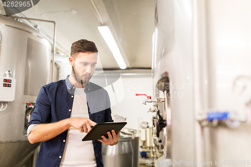 Image of man with tablet pc at craft brewery or beer plant