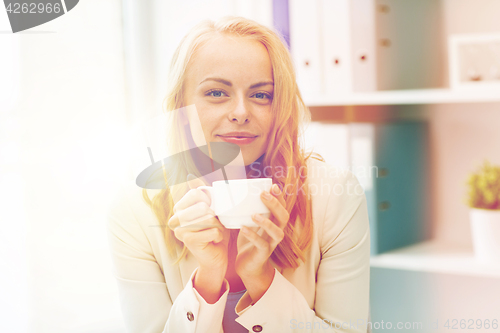 Image of happy businesswoman drinking coffee at office