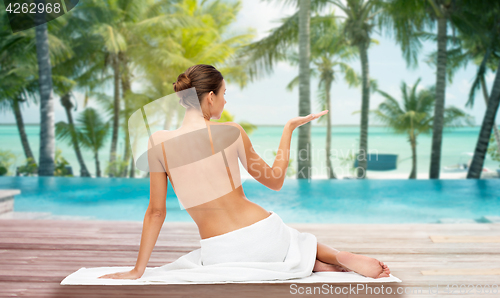 Image of beautiful woman in towel with bare top on beach