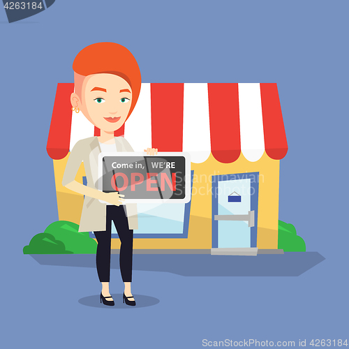 Image of Female shop owner holding open signboard.