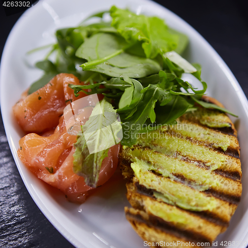 Image of sandwich with smoked salmon, cheese, tomatoes and herbs for healthy breakfast. close up