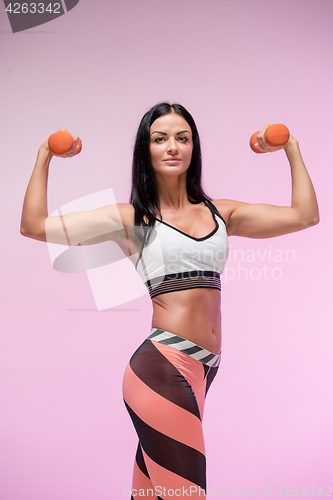 Image of The woman training against pink studio