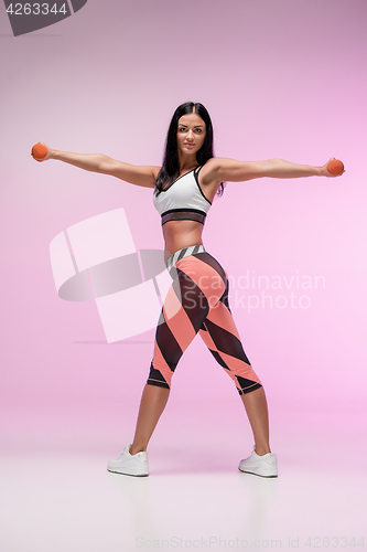 Image of The woman training against pink studio