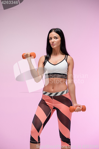 Image of The woman training against pink studio