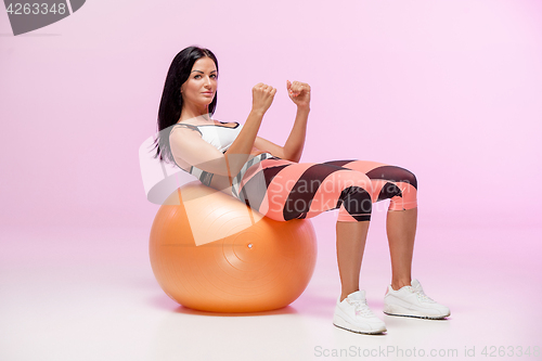 Image of The woman training against pink studio