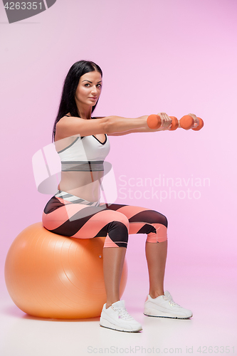 Image of The woman training against pink studio