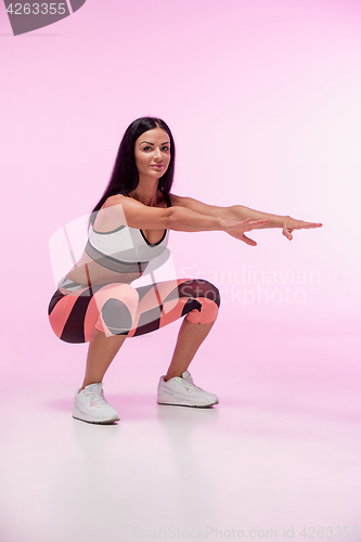 Image of The woman training against pink studio