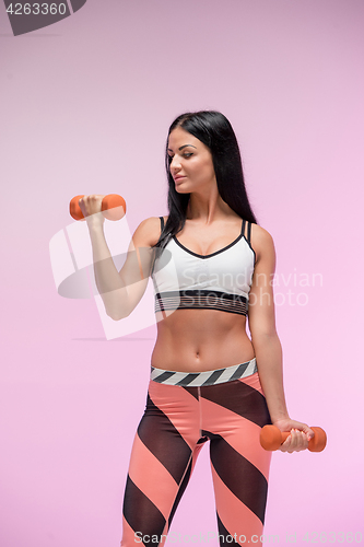 Image of The woman training against pink studio