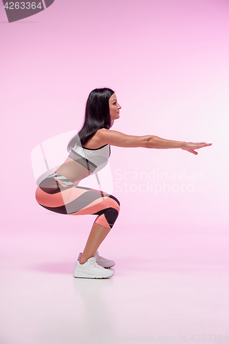 Image of The woman training against pink studio