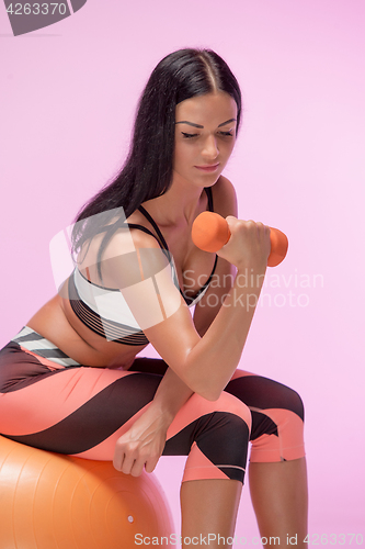 Image of The woman training against pink studio