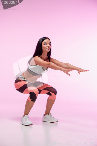 Image of The woman training against pink studio