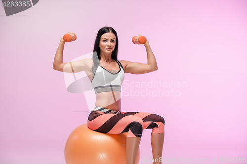 Image of The woman training against pink studio