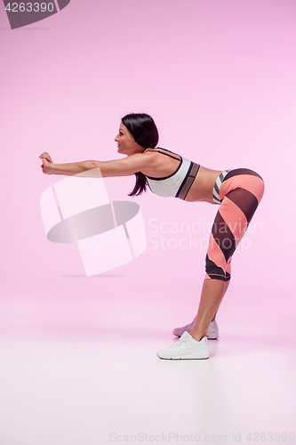 Image of The woman training against pink studio