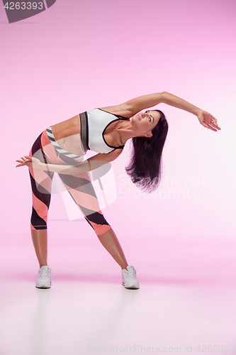 Image of The woman training against pink studio