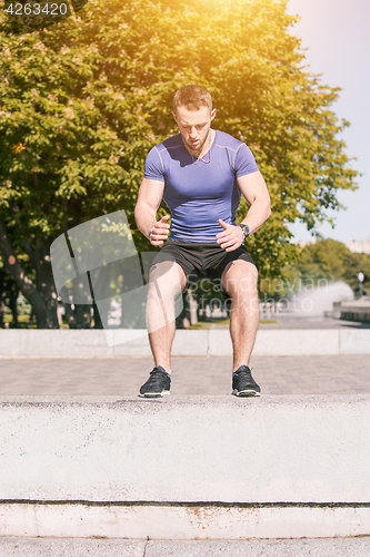 Image of Fit man doing exercises outdoors at park