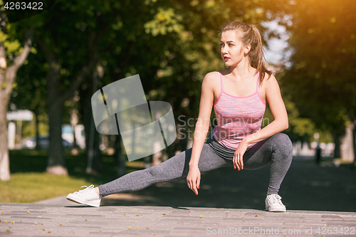 Image of Fit fitness woman doing stretching exercises outdoors at park