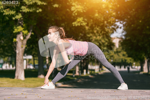 Image of Fit fitness woman doing stretching exercises outdoors at park