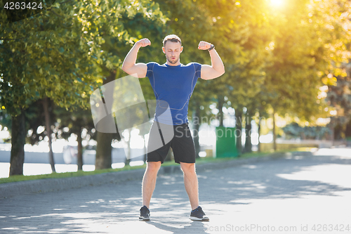 Image of Fit man doing exercises outdoors at park