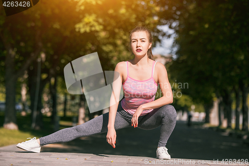 Image of Fit fitness woman doing stretching exercises outdoors at park