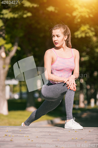 Image of Fit fitness woman doing stretching exercises outdoors at park