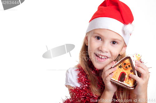 Image of Happy little smiling girl with christmas house.